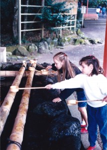 Amaree and Marissa getting holy water at a Shinto Shrine