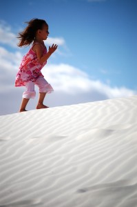 Joselyn runs on a sand dune at White Sands National Monument in NM
