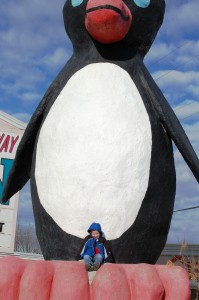 Grandson Charlie is dwarfed by the giant penguin in Cut Bank, Montana