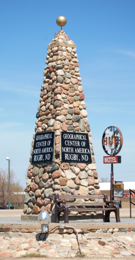 The Rugby Geographical Center of North America monument juxtaposed with the HUB Motel sign in Rugby, ND