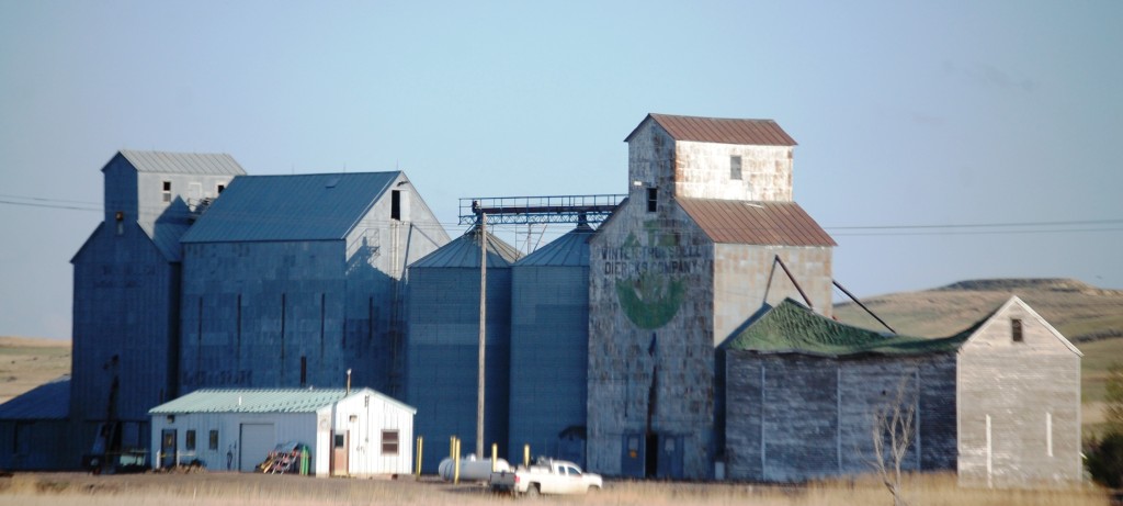 Grain elevators and a barn with a collapsed roof in Bainville, MT on US Route 2