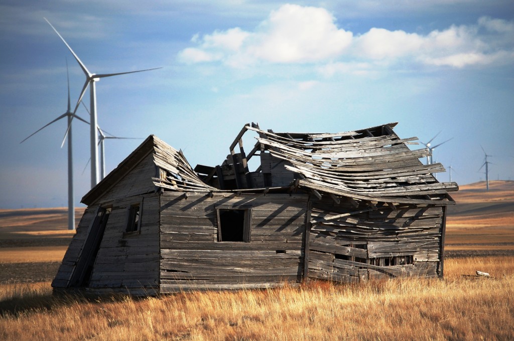 An old cabin falls apart in the midst of the giant wind turbines of the Glacier Wind Farm near Shelby, Montana