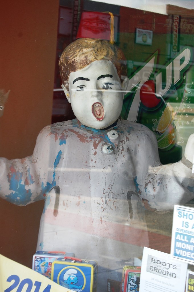 Old retro statue of a boy in the window at Atomic Candy in Denton, TX