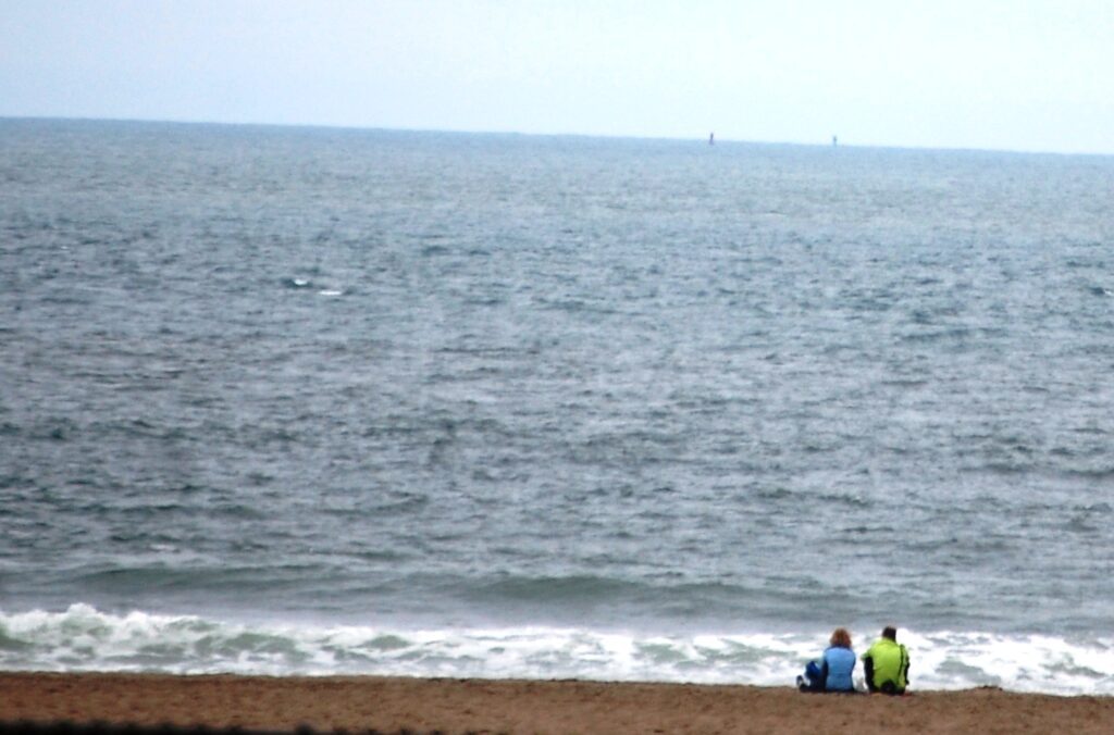 A couple sits on the beach near Golden Gate Park