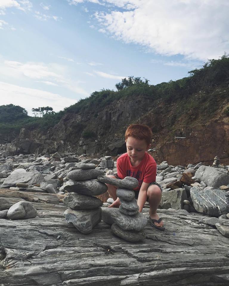 Grandson Landen makes a rock pile on the rocky shores of the Atlantic