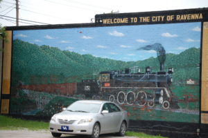 A large mural of a train welcomes visitors to Ravenna, KY