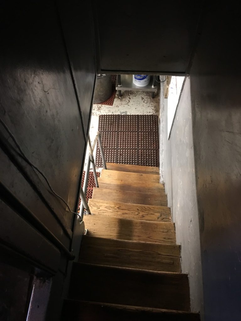 Old rustic stairway down to the decades old basement kitchen