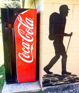 Hiker painting on a restroom wall in Damascus